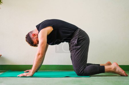 Photo for Man doing yoga in cow cat position - Royalty Free Image