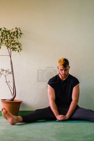 Photo for Man with yingyang hair stretching with closed eyes - Royalty Free Image