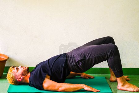 Photo for Blonde man stretching doing the bridge position - Royalty Free Image