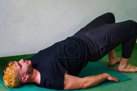 Photo for Strong man with yingyang hair stretching doing the bridge position - Royalty Free Image
