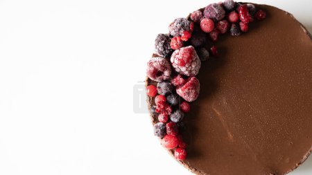 Téléchargez les photos : Gâteau au chocolat avec des berrys rouges sur un fond blanc avec copyspace - en image libre de droit