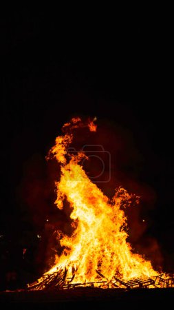 Foto de Hoguera en la playa por la noche con altas llamas - Imagen libre de derechos
