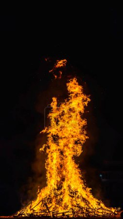 Foto de Torre de llamas en una gran hoguera en la noche en vertical - Imagen libre de derechos