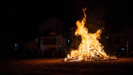 Foto de Celebración rural con la ciudad agujero observando el fuego de una hoguera en la playa por la noche - Imagen libre de derechos