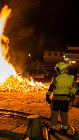 Téléchargez les photos : Pompier regarder un feu de joie dans une plage pour le sauver - en image libre de droit