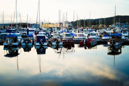 Téléchargez les photos : Port de mer avec quelques bateaux à l'intérieur sur un coucher de soleil bleu - en image libre de droit
