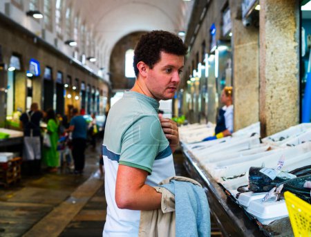 Téléchargez les photos : Homme naviguant dans un marché local de poissons - en image libre de droit