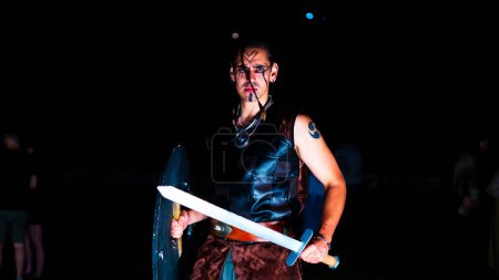 Ein grimmiger muskulöser Krieger mit einem Schwert in der Hand. Wikinger