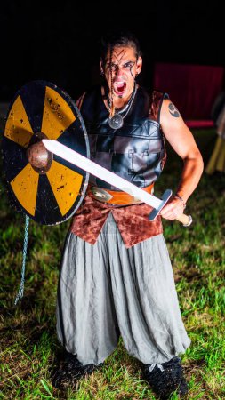 Photo for Viking warrior with black war paint, holding his axe. - Royalty Free Image