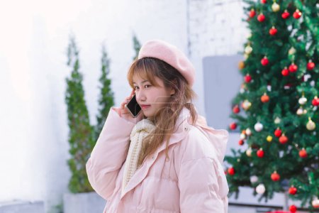 Téléchargez les photos : La fille tenant un téléphone pendant l'hiver chaud - en image libre de droit