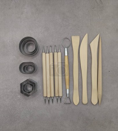 Cutters, wooden and metal sculpt tools on gray cement background