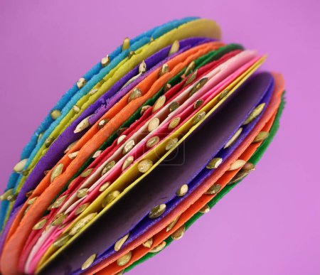 Colorful mexican sweets, pepitorias, on purple background, seen from above