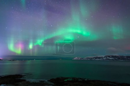 Foto de Maravillosas luces del norte en Troms en los Lyngenalps. inspirador juego de luces en el cielo nocturno, aurora boreal cerca de Tromso en Sommaroy, Noruega - Imagen libre de derechos