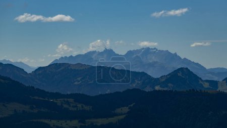 Foto de Siluetas de montaña en el panorama del Bregenzerwald, con Sntis en el fondo. El atardecer rojo y la neblina hacen visibles los contornos. - Imagen libre de derechos