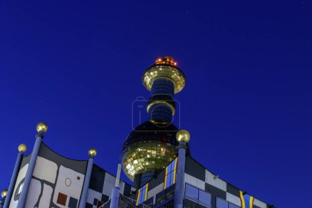 Photo for Vienna, Austria 20 Aug 2023: Spittelau - Vienna's waste incineration factory, designed by Hundertwasser, marries art with function, and shines as an eco-friendly icon in the night. - Royalty Free Image