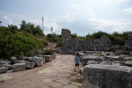 Téléchargez les photos : Homme marchant dans les ruines de la ville grecque antique de delphes dans la journée ensoleillée, Grèce - en image libre de droit