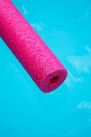 Photo for Pink pool noodle floating on the blue water - Royalty Free Image