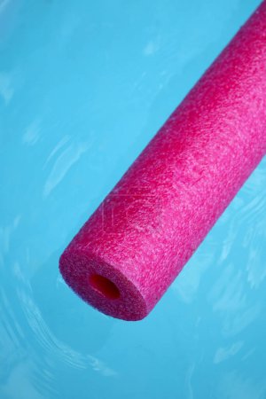 Photo for Pink pool noodle floating on the blue water - Royalty Free Image