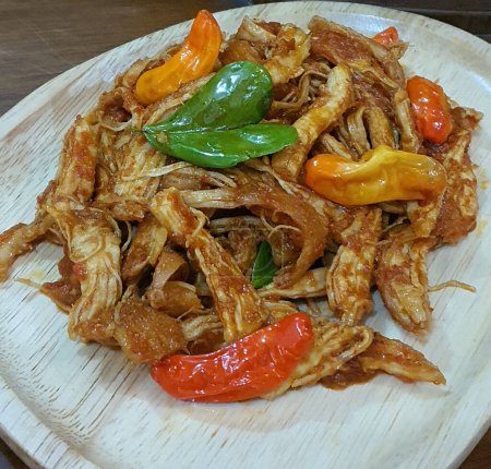 Le balado Ayam ou poulet frit épicé est un plat traditionnel de Padang, dans l'ouest de Sumatra. Servis sur une longue assiette blanche, les plats sont épicés et gras. Concentration sélective.