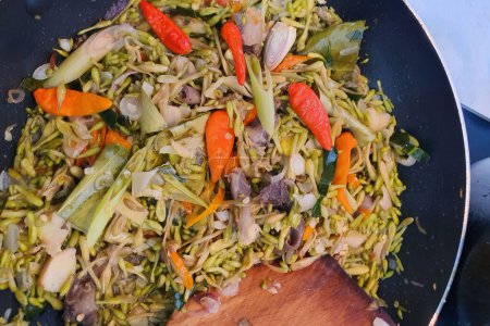 Sayur Bunga Pepaya, ein Manado oder Minahasan indonesische Küche rühren gebratene Gemüseküche aus Papaya-Blüten hausgemachte Köchin