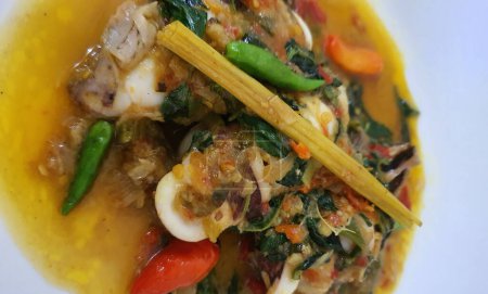 Téléchargez les photos : Tumis Cumi Cabe ou mélanger les calamars frais frits avec du piment vert et du piment thaï rouge, servis dans un bol blanc. Plat traditionnel indonésien. Concentration sélective. - en image libre de droit