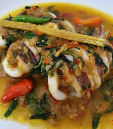 Tumis Cumi Cabe ou mélanger les calamars frais frits avec du piment vert et du piment thaï rouge, servis dans un bol blanc. Plat traditionnel indonésien. Concentration sélective.