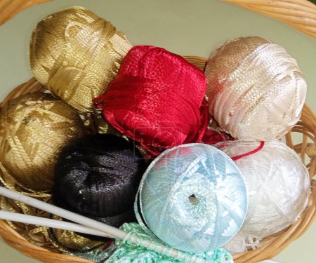 Téléchargez les photos : Boules de fils multicolores lumineuses pour le tissage dans un panier - en image libre de droit