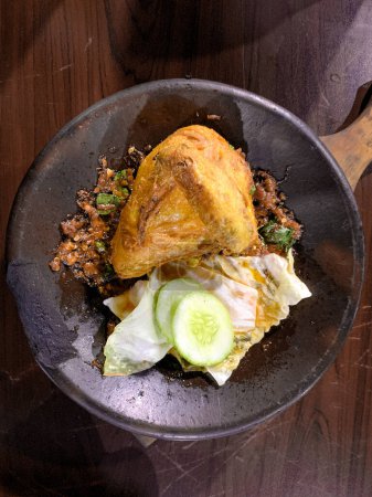 Foto de Delicias saladas de Indonesia: Vista plana de pollo frito y Sambal Bakar presentado en Cobek - Imagen libre de derechos