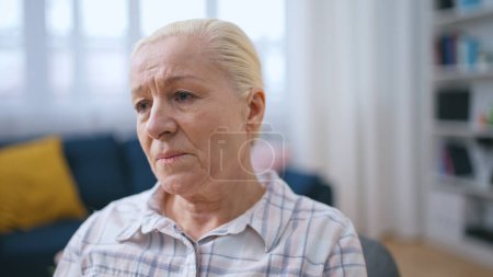 Mujer mayor frustrada sintiéndose sola en casa, familia desaparecida durante el encierro