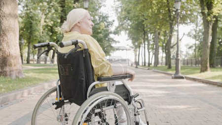Foto de Mujer rubia pensativa sentada en silla de ruedas, condición de salud crónica, lesión - Imagen libre de derechos