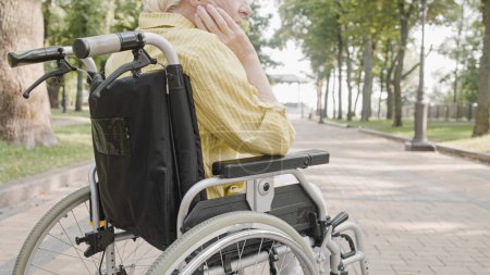 Foto de Mujer jubilada con discapacidad física que se relaja en el parque, usuaria de silla de ruedas - Imagen libre de derechos