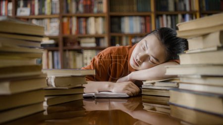 Téléchargez les photos : Fatigué asiatique étudiant dormir sur pile de livre, prendre une pause de l'étude - en image libre de droit