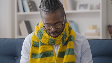 Téléchargez les photos : Afro-Américain en écharpe souffrant de grippe et de symptômes de rhume, travaillant à la maison - en image libre de droit