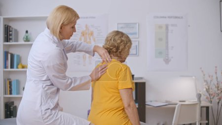 Photo for A vertebrology clinic doctor examines a senior patient's spine, conducting disease diagnostics - Royalty Free Image