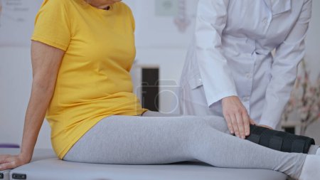 Eine Ärztin immobilisiert einen Knochen im Bein einer Patientin mit einem Gips und behandelt ein Trauma