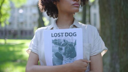 Mujer voluntaria sosteniendo en las manos carteles con foto de perro desaparecido, rescate de animales
