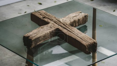 Croix en bois sur une table en verre