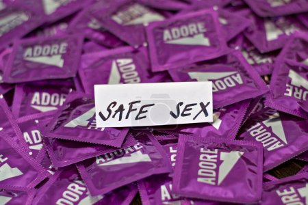 Téléchargez les photos : Paquet de préservatifs pour des relations sexuelles sans risque. Emballage violet. Protection et prévention des maladies. Temps de sexe. - en image libre de droit