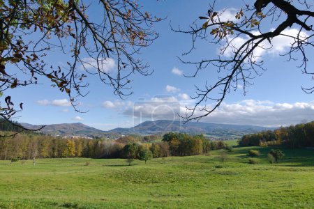 Téléchargez les photos : Radhost montagne et collines environnantes près de Roznov pod Radhostem, belle petite ville en République tchèque. Paysage avec champs, pâturages et prairies et ciel bleu nuageux. Journée ensoleillée d'automne. - en image libre de droit