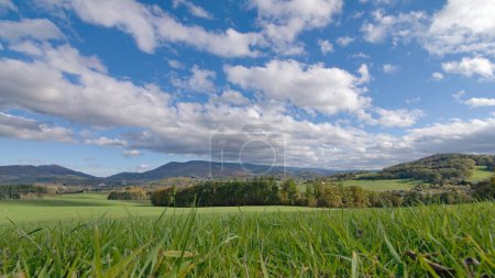 Photo for Radhost mountain and surrounding hills near to Roznov pod Radhostem, lovely small town in Czech republic. Landscape with fields, pastures and meadows and cloudy blue sky. Sunny autumn day. - Royalty Free Image
