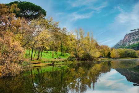 Hermoso paisaje otoñal de las orillas del río Alberche, España, en el embalse de Picadas con los árboles reflejados en el agua.