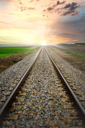Téléchargez les photos : Trains de train en perspective avec le soleil levant en arrière-plan. - en image libre de droit