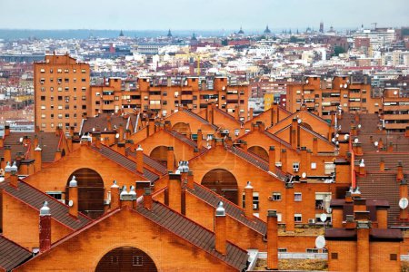 Dichte Ansammlung von Häusern im Viertel Moratalaz von Madrid (Spanien), mit dem Zentrum von Madrid im Hintergrund.