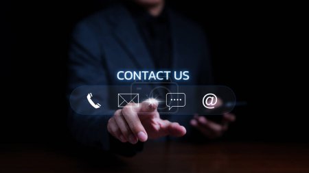 Photo for Contact us or the Customer support hotline people connect. Businessman using mobile phone and using hand touching virtual icons call phone, email, address, and live chat. Customer service call center. - Royalty Free Image