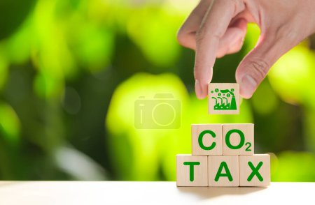 Carbon tax concept. Environmental and social responsibility business. Taxation for nature pollution. Wooden cubes with CO2 TAX word and factory icon. Carbon pricing and credits, Climate finance,