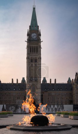 Centennial Flame monument on Parliament Hill commemorating the 100th anniversary of the Canadian Confederation, with the Peace Tower at dusk, Ottawa, Ontario, Canada. Photo taken in May 2023.
