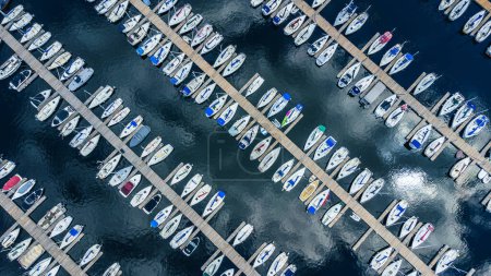 Photo for Aerial top down view of boats docking at marina, docks creating diagonal lines, with clouds reflecting on water river, Nepean Sailing Club, Ottawa, Ontario, Canada. Photo taken by drone in July 2021. - Royalty Free Image