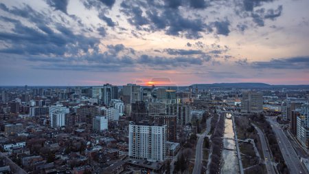 Vista panorámica aérea de la puesta de sol sobre el canal de Rideau, Parliament Hill, el centro de Ottawa, Ontario y Gatineau, Gatineau Park Hills, Outaouais, Quebec, Canadá Drone foto, abril 2021