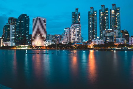 Foto de Bangkok, Tailandia. 4 de julio de 2022. Bangkok centro de negocios por la noche con vista al lago en Benchakitti Park - Imagen libre de derechos