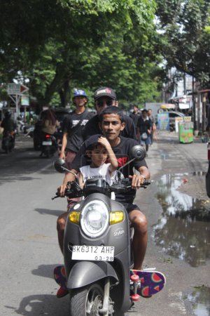 Téléchargez les photos : Un homme asiatique et un garçon en moto célèbrent la journée de skateboard. Indonésie - Medan, 21 juin 2024 - en image libre de droit